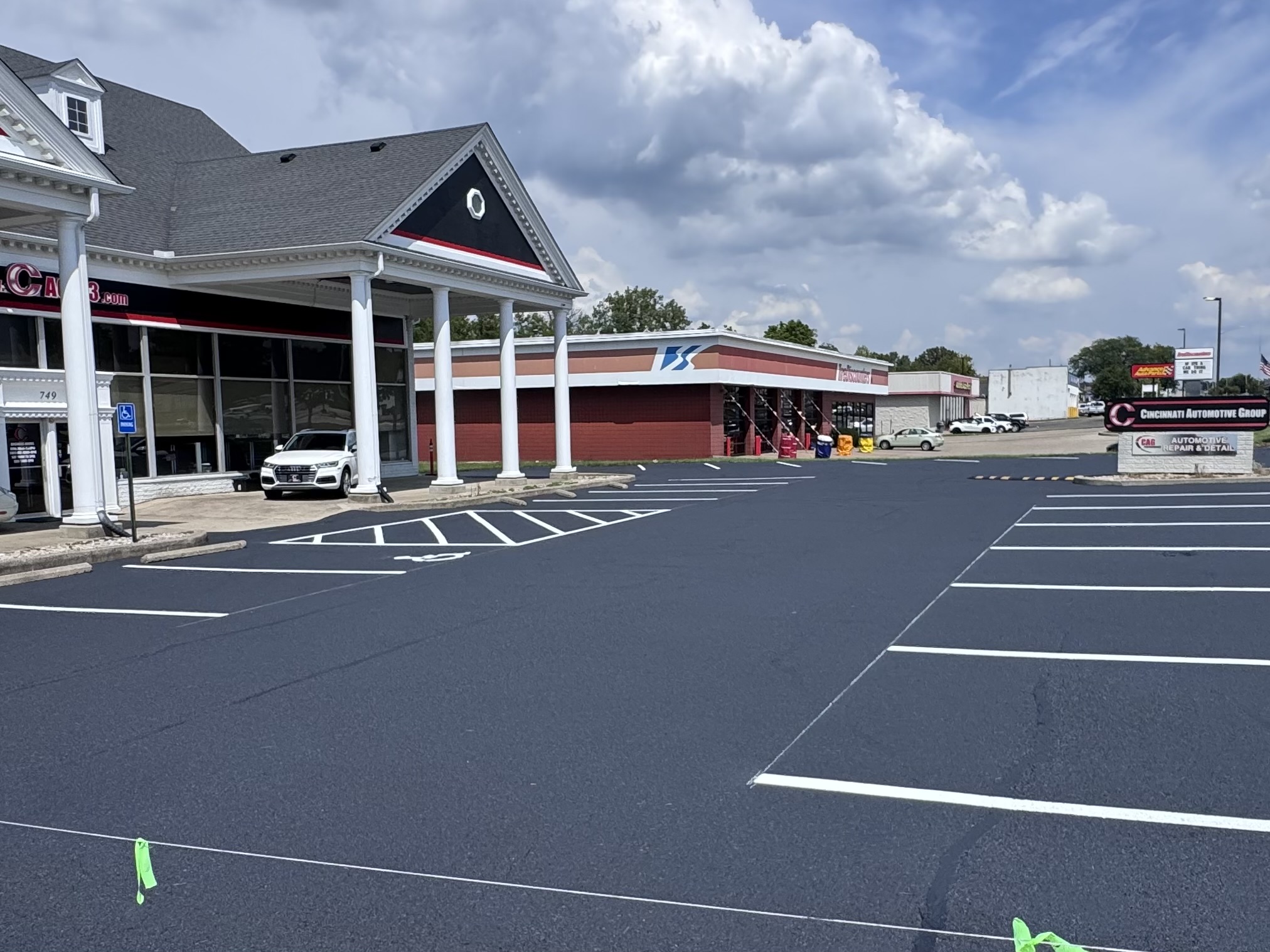 Freshly sealcoated commercial parking lot with crisp white striping